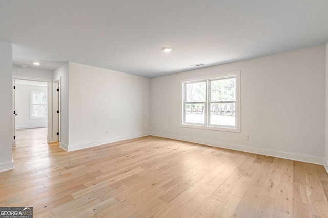 empty room with baseboards, recessed lighting, and light wood-style flooring