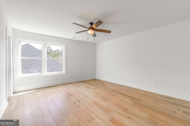 spare room with ceiling fan, baseboards, and light wood-type flooring