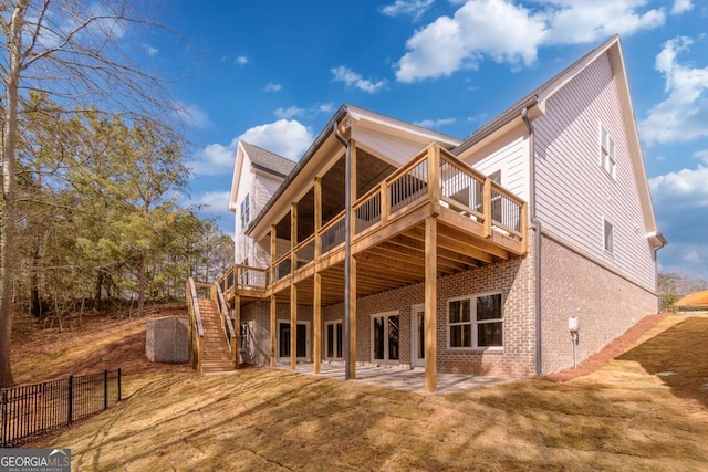 rear view of property featuring a wooden deck, a yard, stairway, and brick siding