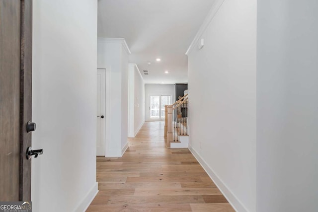 hallway with baseboards, recessed lighting, light wood-style floors, and an upstairs landing
