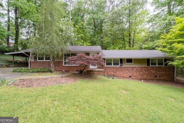 split level home featuring brick siding, crawl space, a front yard, and a carport