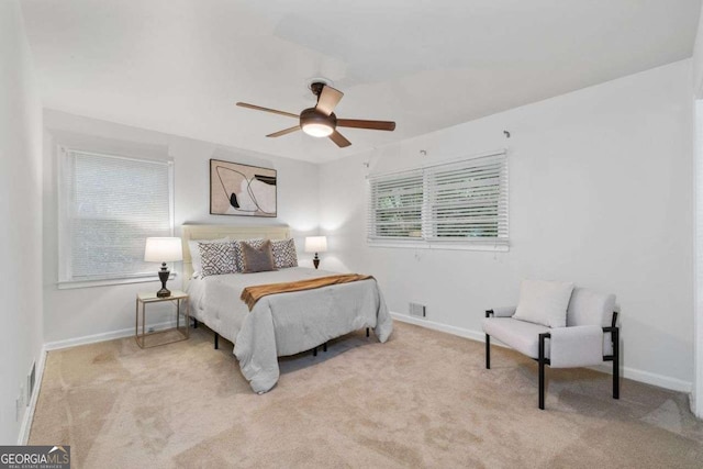 carpeted bedroom with a ceiling fan, baseboards, and visible vents