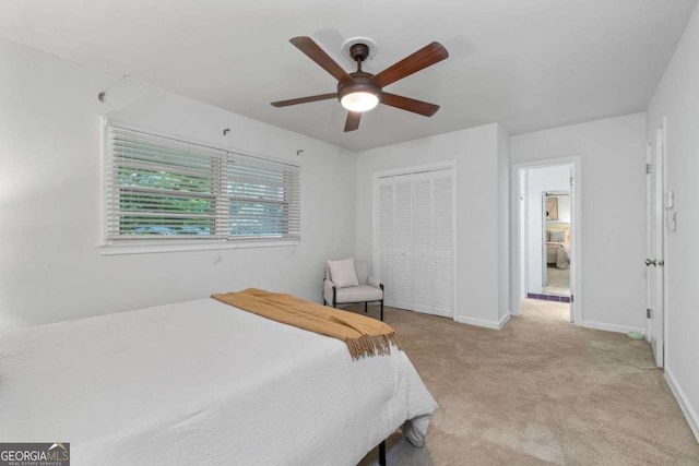 bedroom with baseboards, a ceiling fan, a closet, and light colored carpet