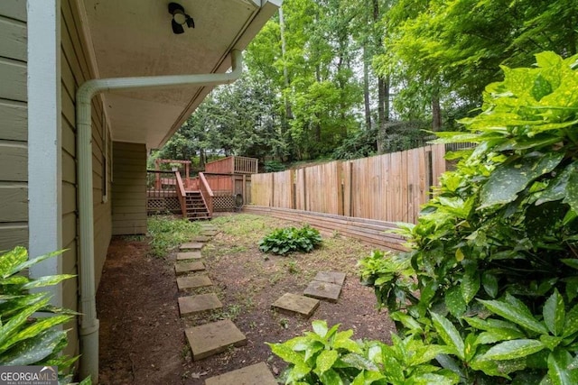 view of yard featuring fence, stairway, and a deck