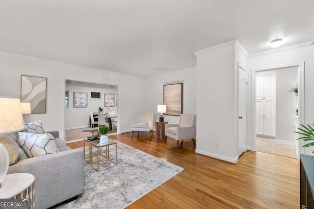 living room featuring crown molding, baseboards, and wood finished floors