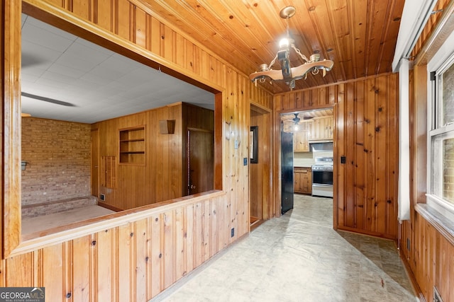 hall with visible vents, tile patterned floors, and wooden walls