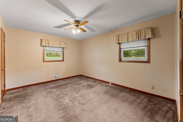 spare room featuring visible vents, a ceiling fan, carpet, and baseboards