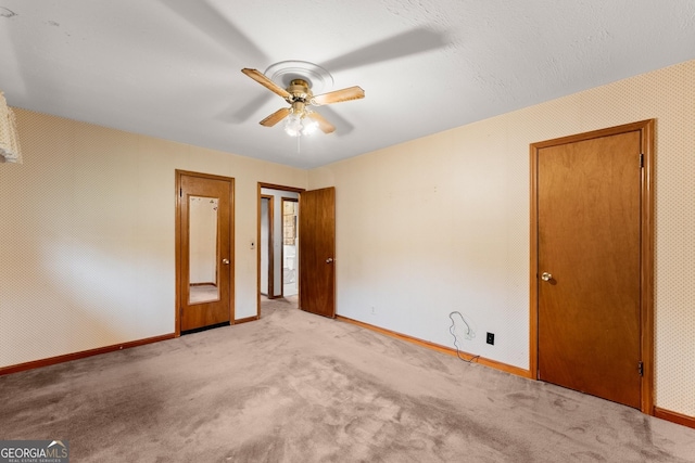 interior space with baseboards, ceiling fan, and carpet flooring
