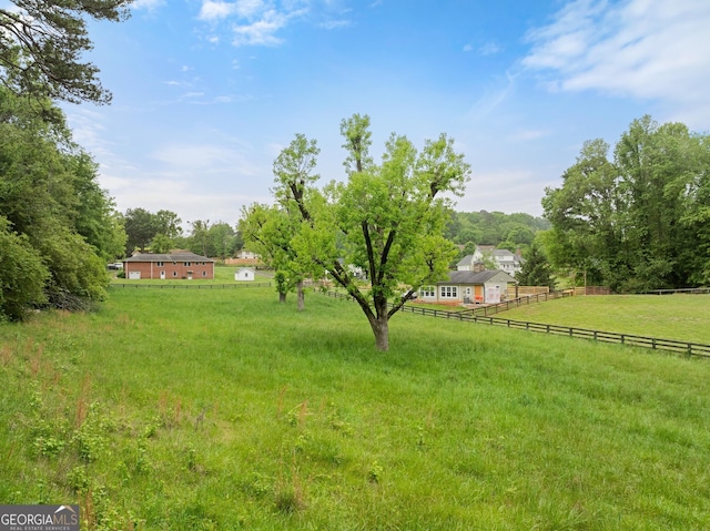 view of yard featuring fence and a rural view