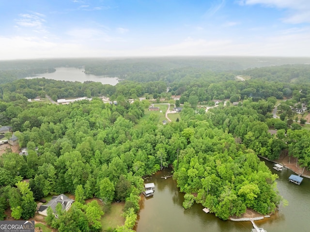 drone / aerial view featuring a water view and a wooded view
