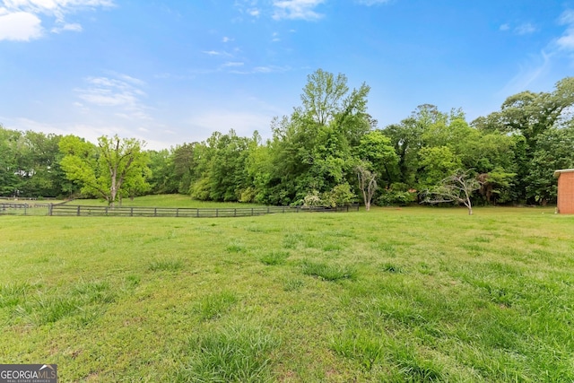 view of yard featuring a rural view and fence