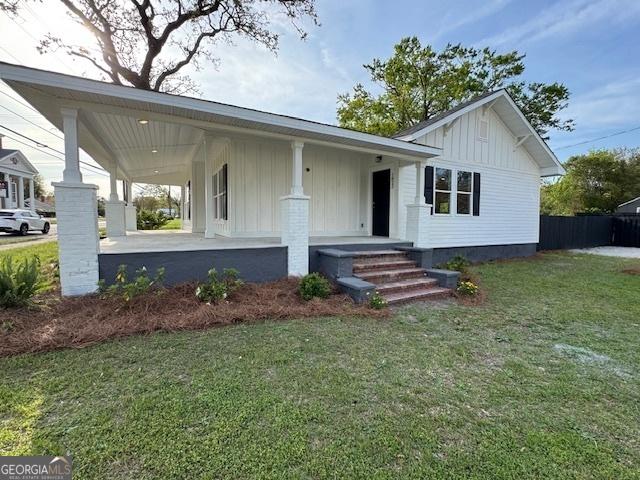 1823 Wrightsboro Rd, Augusta, GA 30904 - view of front facade featuring board and batten siding, covered porch, and a front lawn