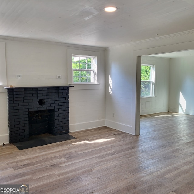 unfurnished living room with crown molding, baseboards, a healthy amount of sunlight, and wood finished floors