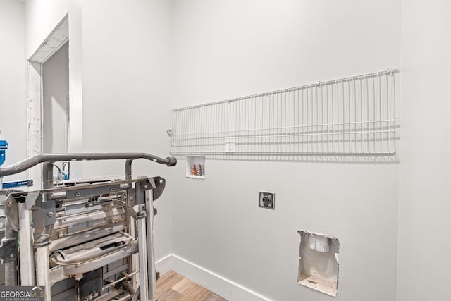 laundry area with laundry area, hookup for a washing machine, baseboards, electric dryer hookup, and wood finished floors