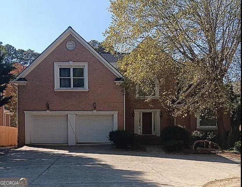 4746 Chamblee Dunwoody Rd, Atlanta, GA 30338 - view of front facade with an attached garage, driveway, and brick siding