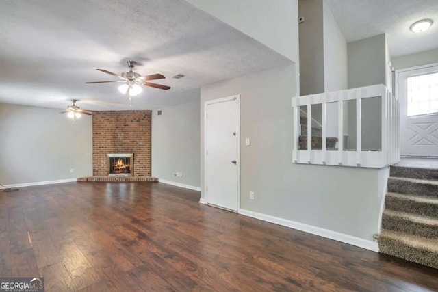 5379 Winslow Xing, Lithonia, GA 30038 - unfurnished living room featuring ceiling fan, a fireplace, baseboards, wood finished floors, and stairway