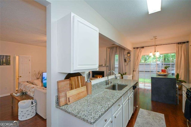 kitchen with dark wood-style flooring, light stone counters, an inviting chandelier, a sink, and white cabinetry