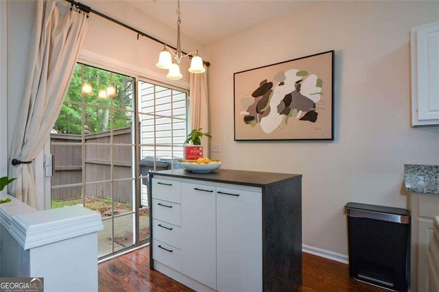 dining room with baseboards, dark wood-type flooring, and a chandelier