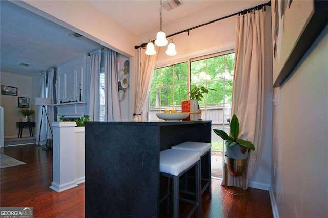 interior space featuring a chandelier, baseboards, visible vents, and wood finished floors
