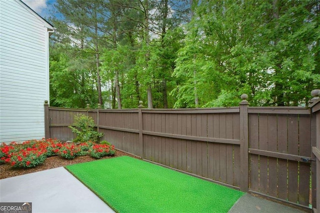 view of yard featuring fence and a patio