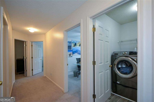 washroom with washer / clothes dryer, a textured ceiling, baseboards, and carpet flooring