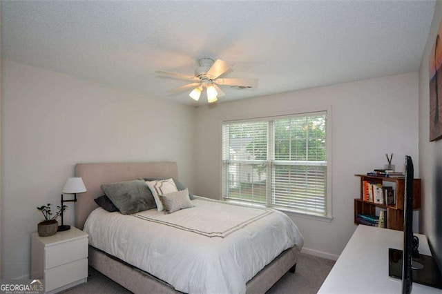 carpeted bedroom featuring baseboards, a ceiling fan, and visible vents