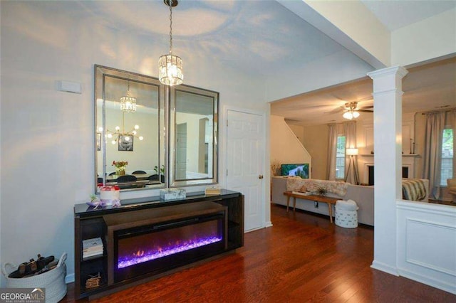interior space featuring ornate columns, wood finished floors, and a chandelier