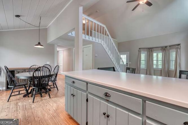kitchen featuring ceiling fan, light wood finished floors, light countertops, gray cabinets, and lofted ceiling