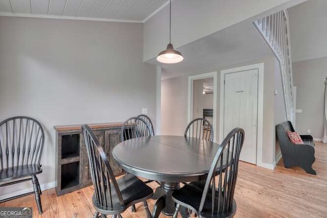 dining area with baseboards, light wood finished floors, and crown molding