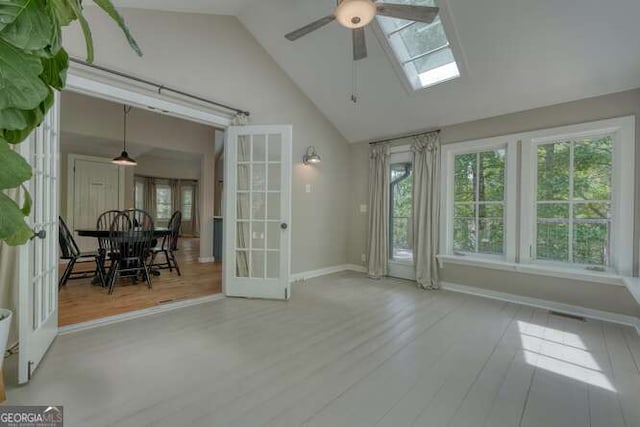 sunroom with french doors, a healthy amount of sunlight, and a skylight