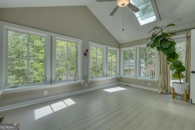 unfurnished sunroom featuring lofted ceiling with skylight, wood finished floors, and a wealth of natural light