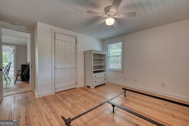 unfurnished bedroom featuring baseboards, multiple windows, and light wood-type flooring