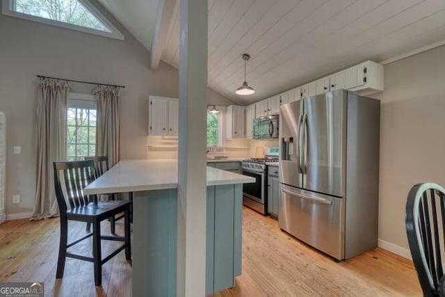 kitchen with light countertops, vaulted ceiling with beams, stainless steel appliances, and light wood-type flooring