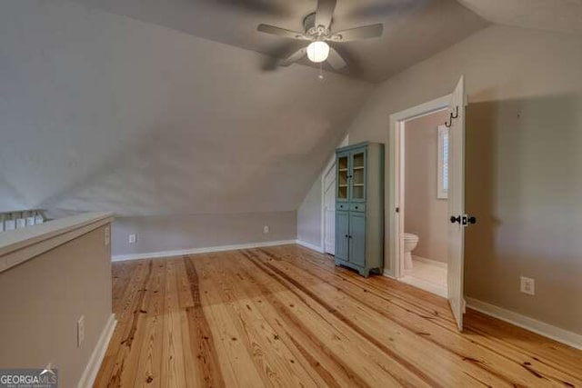 bonus room featuring light wood-style floors, baseboards, a ceiling fan, and vaulted ceiling