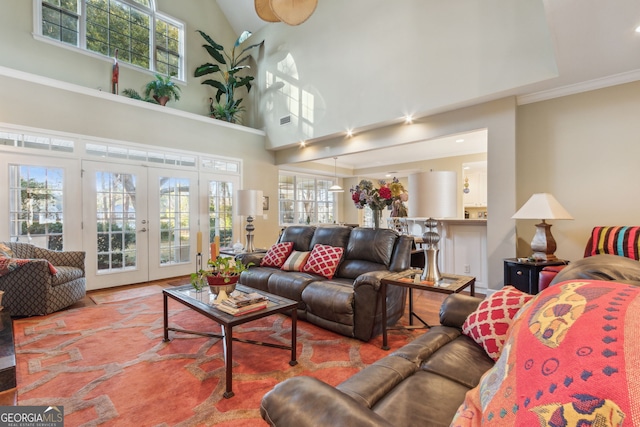 living room featuring plenty of natural light, a high ceiling, visible vents, and french doors