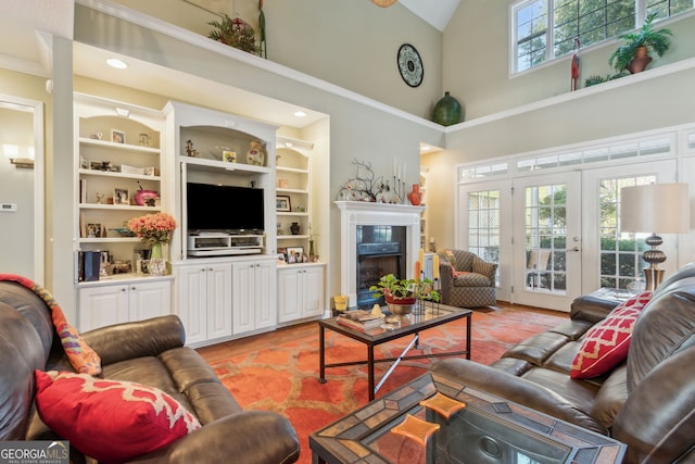 living area featuring light tile patterned flooring, high vaulted ceiling, built in shelves, french doors, and a high end fireplace