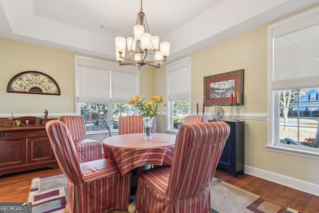 dining room with baseboards, an inviting chandelier, and wood finished floors