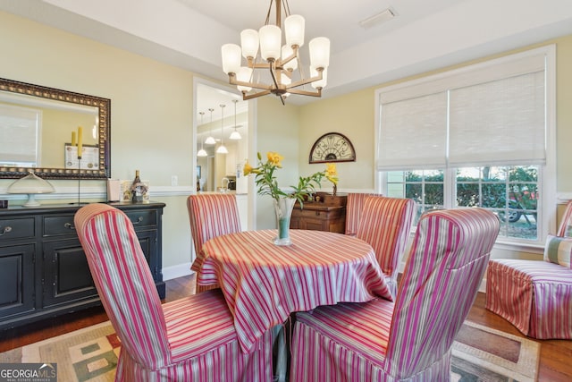 dining space featuring an inviting chandelier, dark wood-type flooring, and visible vents