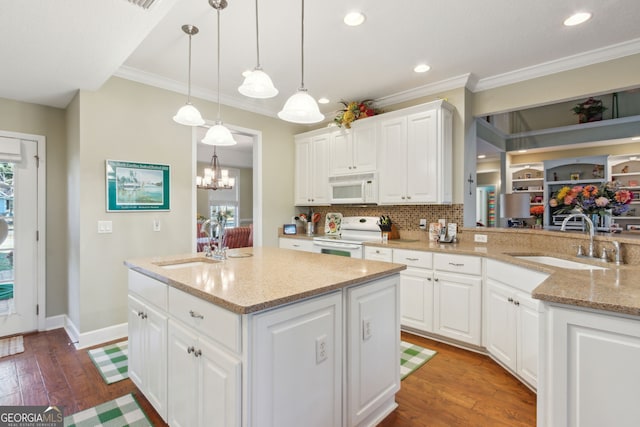 kitchen featuring white appliances, ornamental molding, and a sink