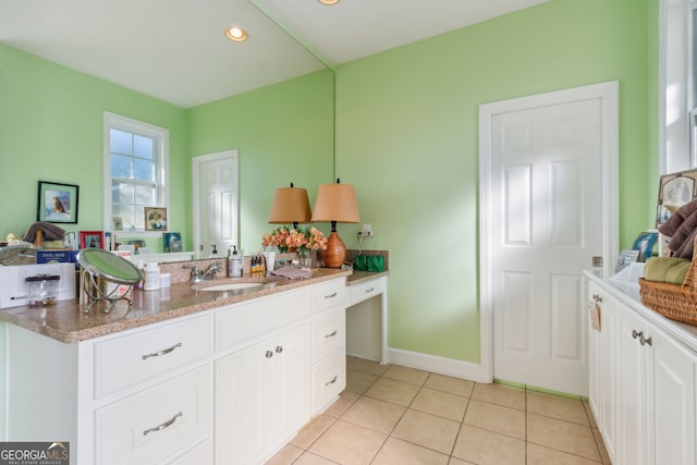 kitchen with light tile patterned flooring, light stone countertops, a sink, recessed lighting, and white cabinetry