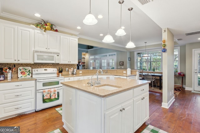 kitchen with visible vents, ornamental molding, white appliances, a sink, and backsplash