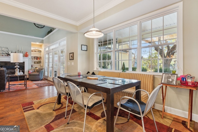 dining space featuring crown molding, french doors, baseboards, and wood finished floors