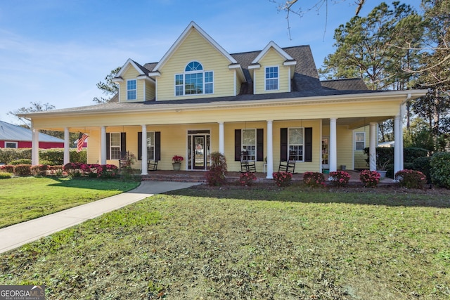 farmhouse inspired home with a porch, a shingled roof, and a front lawn