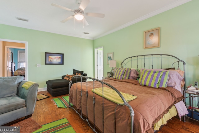 bedroom with visible vents, ornamental molding, and wood finished floors