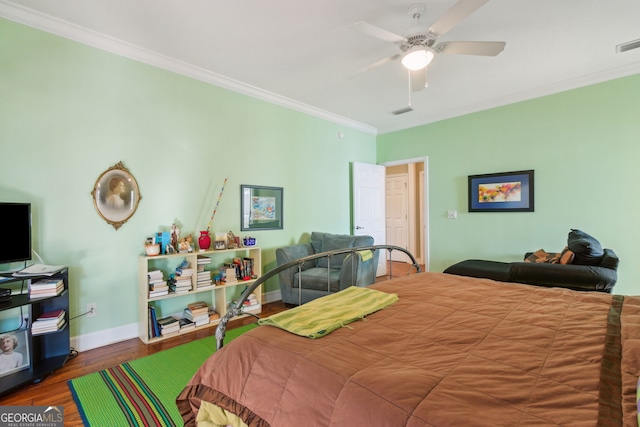 bedroom with crown molding, ceiling fan, baseboards, wood finished floors, and visible vents