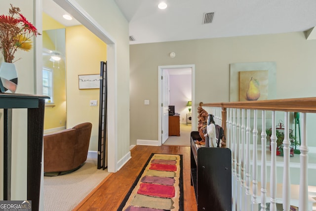 hall featuring baseboards, recessed lighting, wood finished floors, and visible vents