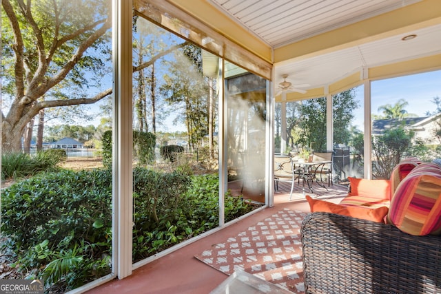 sunroom / solarium featuring a ceiling fan