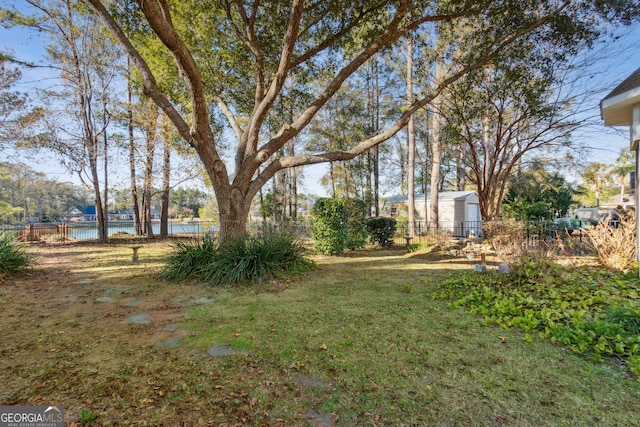 view of yard with a water view and fence