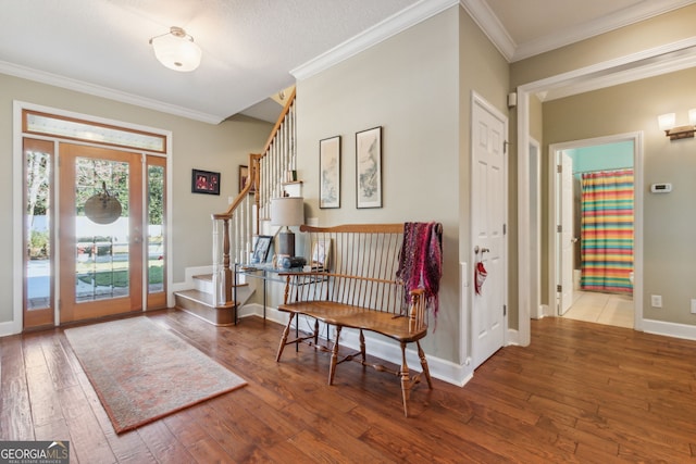 entryway featuring crown molding, baseboards, stairs, and hardwood / wood-style floors