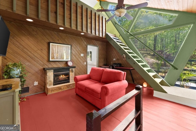 115 Rabbit Run, Dawsonville, GA 30534 - living room with wooden walls, ceiling fan, a stone fireplace, wood finished floors, and stairway